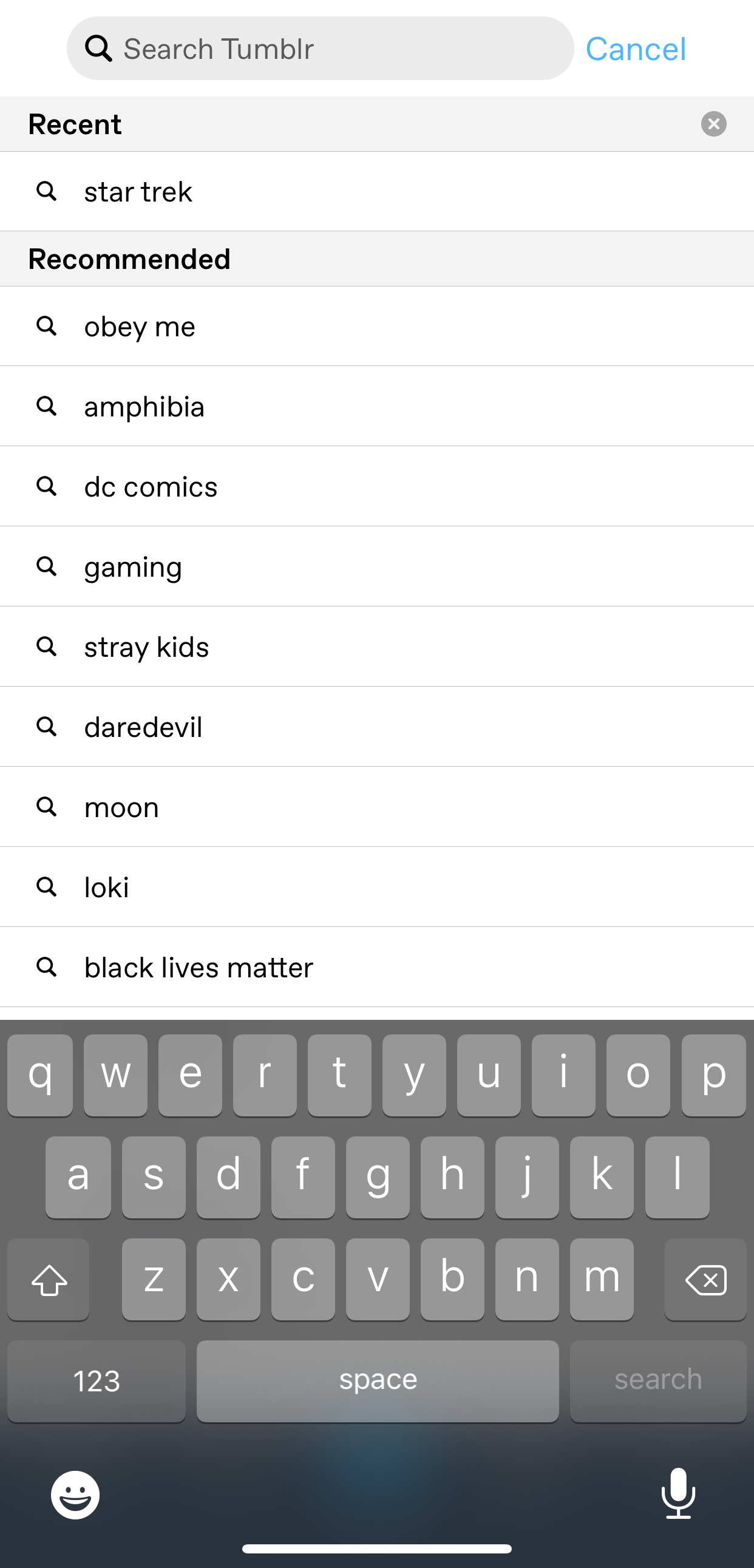 The search interface in the iOS app. At the top is the search field with a magnifying glass icon and the placeholder text: Search Tumblr. To the right of the search field is a Cancel button. Below is a section labeled Recent. There's one entry: star trek. There's a magnifying glass icon next to this entry. The next section is labeled Recommended, and there are many entries. Each entry has a magnifying glass icon to the left of it. The entries are: obey me, amphibia, dc comics, gaming, stray kids, daredevil, moon, loki, and black lives matter. The rest of the entries are covered by the iPhone keyboard.